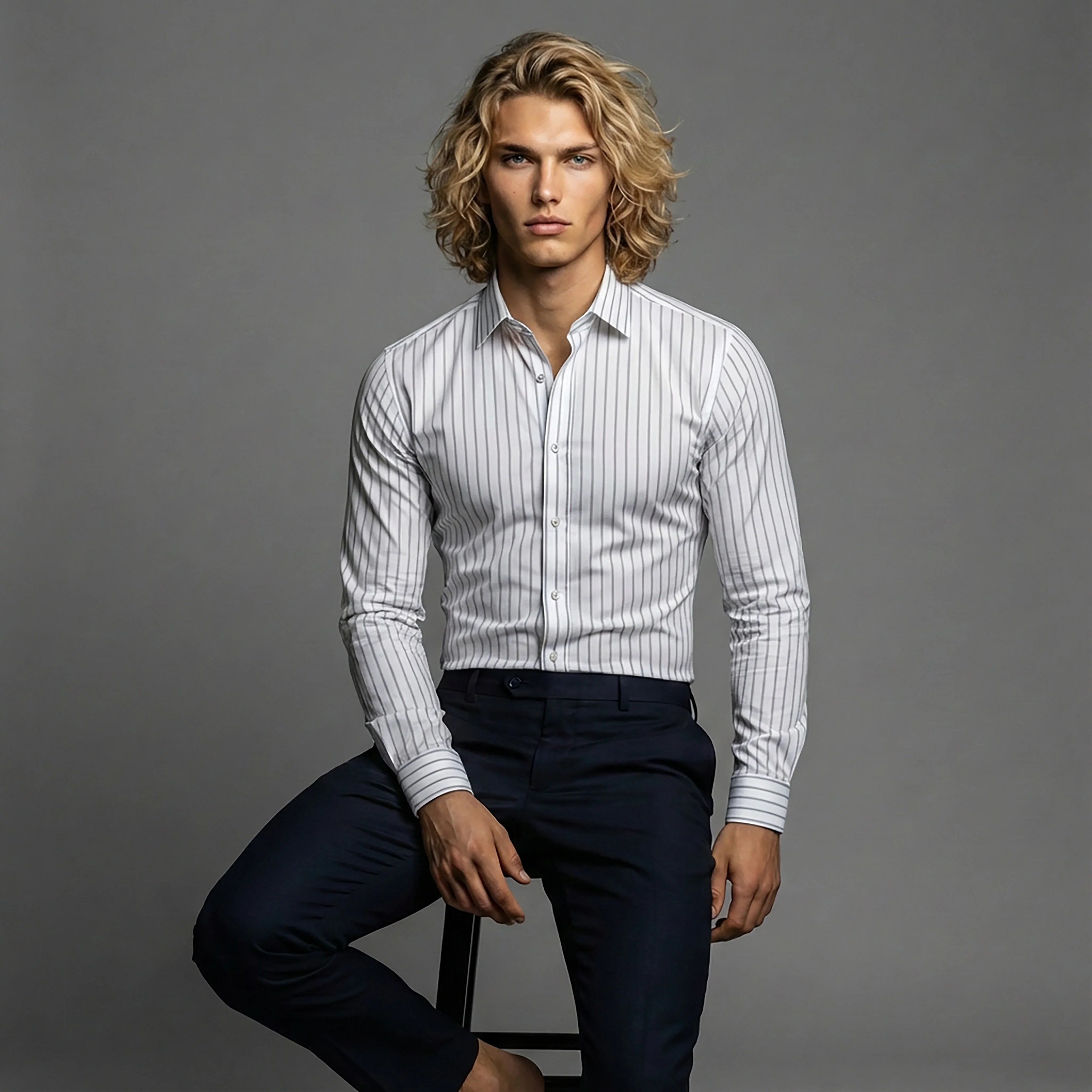 Man wearing a white striped dress shirt and dark trousers, studio fashion shoot for DGMAH